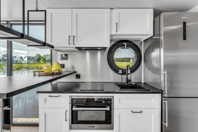 Slide: The Image of Modern kitchen in Waterlodge Apart XXL 2025, featuring sleek appliances and a scenic window view. - 8