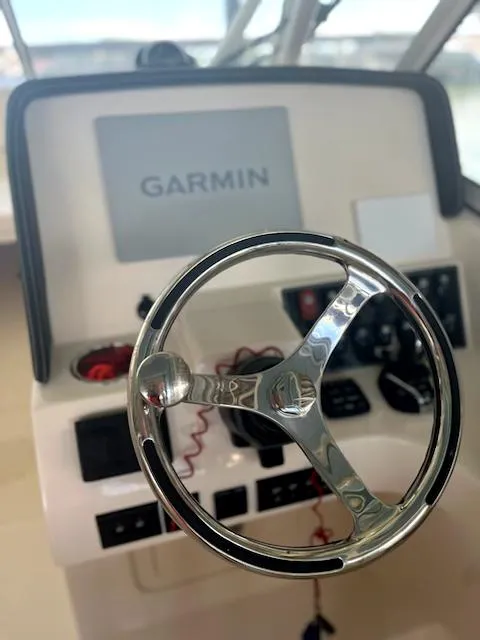 Slide: The Image of 2024 Grady-White Freedom 275 helm with Garmin navigation system and steering wheel. - 2