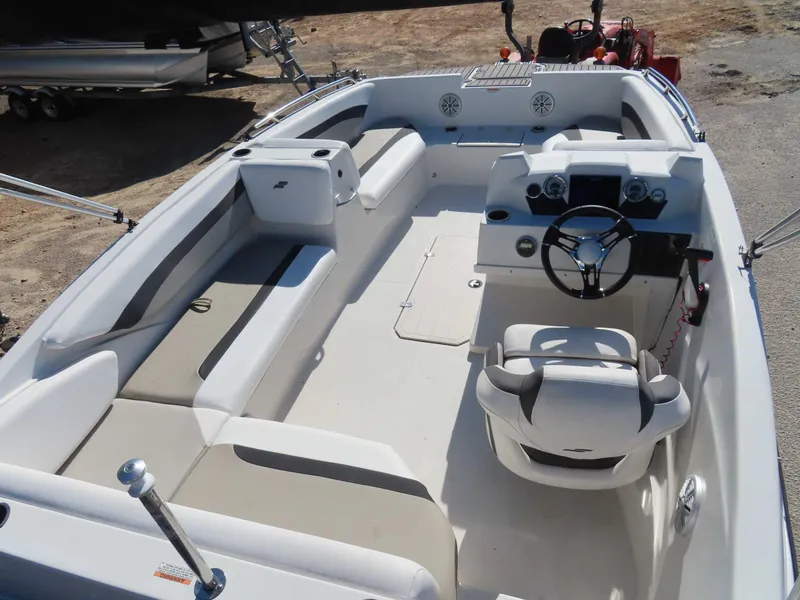 Slide: The Image of 2022 Starcraft SVX 171 boat interior with seating and steering wheel, parked on land. - 18