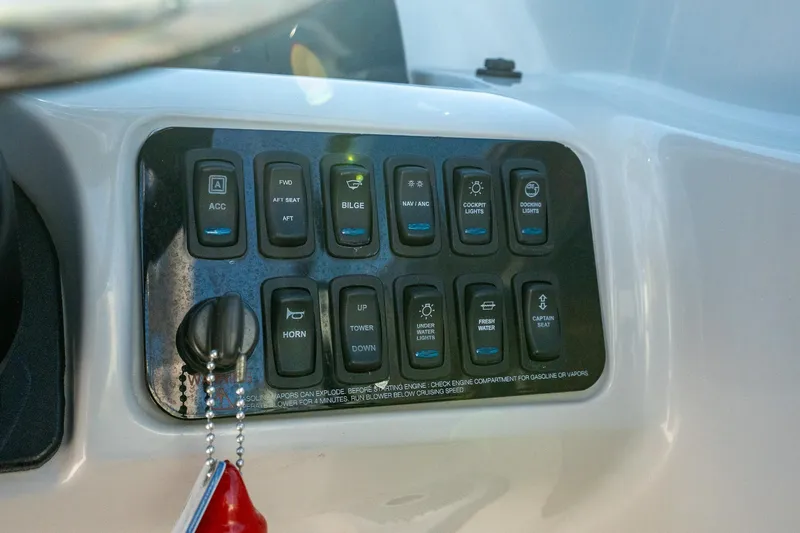 Slide: The Image of Control panel of a 2022 Regal LX2 boat with various switches and keychain. - 16
