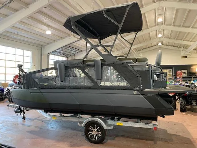 The Image of 2025 Sea-Doo Switch Fish 18 pontoon boat in showroom, featuring sleek design and canopy. - 0
