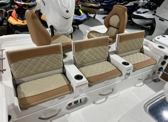 Slide: The Image of 2025 NauticStar 274 Bay boat seating with tan and cream upholstery, featuring cup holders. - 3