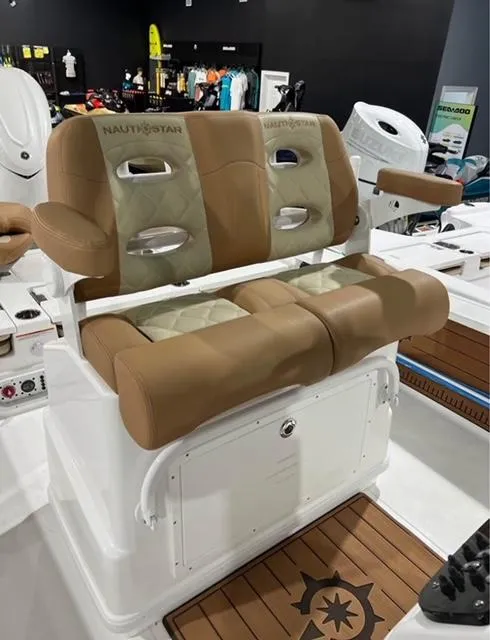 Slide: The Image of 2025 NauticStar 274 Bay boat seating with tan and cream upholstery in showroom. - 4