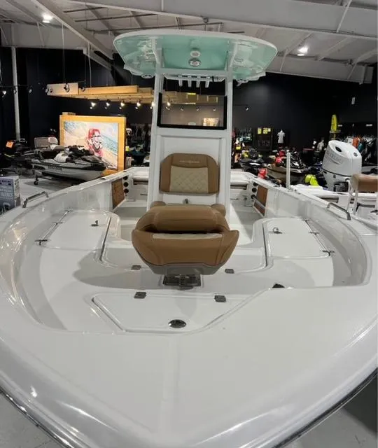 Slide: The Image of 2025 NauticStar 274 Bay boat interior with seating, displayed in a showroom. - 6