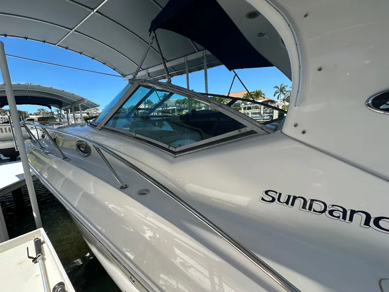 Slide: The Image of 2005 Sea Ray 320 Sundancer boat docked under a canopy on a sunny day. - 10