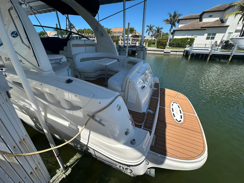 Slide: The Image of 2005 Sea Ray 320 Sundancer docked, featuring spacious deck and seating area. - 11