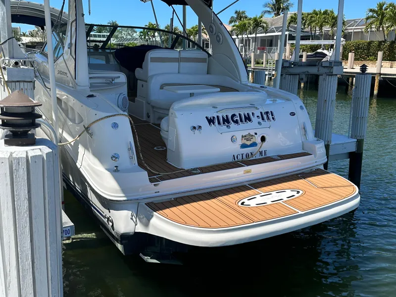 Slide: The Image of 2005 Sea Ray 320 Sundancer docked, featuring spacious deck and seating area. - 12