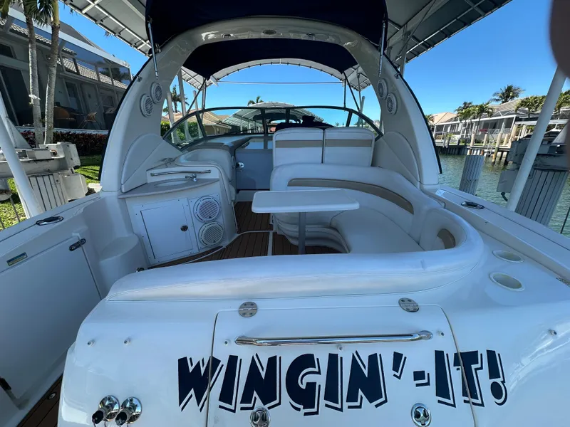 Slide: The Image of 2005 Sea Ray 320 Sundancer boat with "Wingin'-It!" text, docked in a marina. - 13