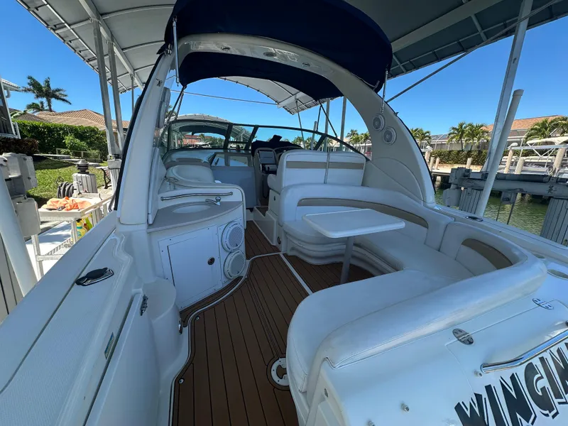 Slide: The Image of 2005 Sea Ray 320 Sundancer boat interior with seating and table under canopy. - 14
