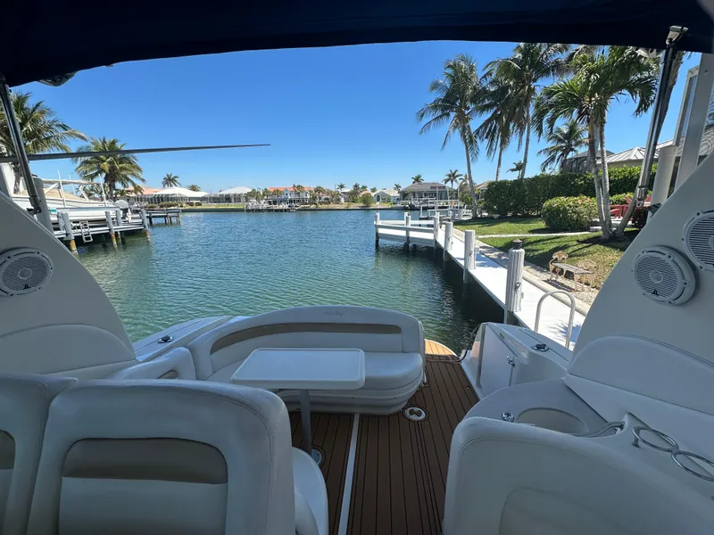 Slide: The Image of 2005 Sea Ray 320 Sundancer yacht docked, with scenic waterfront and palm trees. - 16