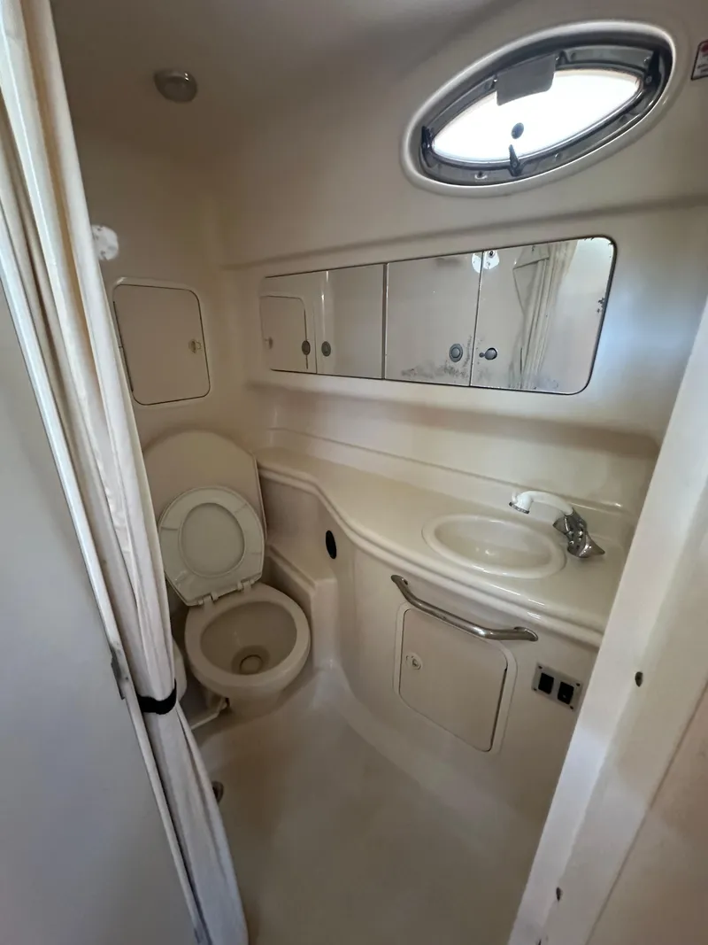 Slide: The Image of 2005 Sea Ray 320 Sundancer bathroom with sink, toilet, and storage cabinets. - 26