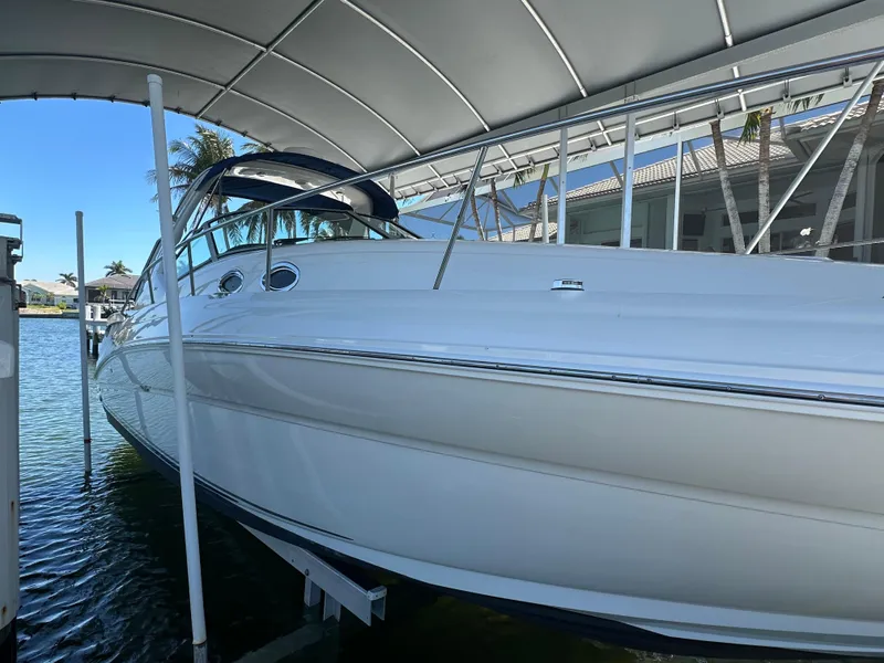 Slide: The Image of 2005 Sea Ray 320 Sundancer docked under a canopy, side view. - 3
