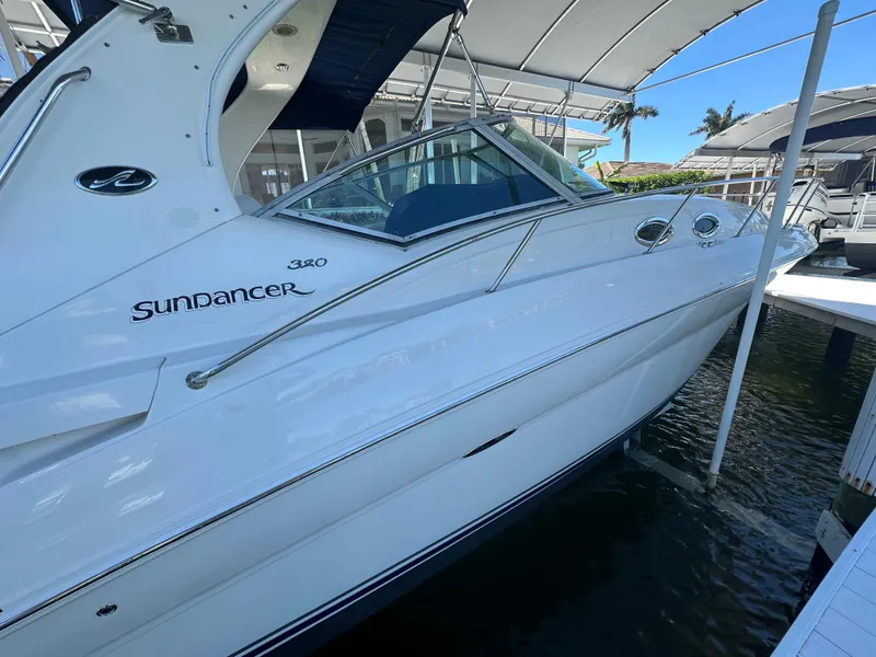 Slide: The Image of 2005 Sea Ray 320 Sundancer boat docked under a canopy. - 4