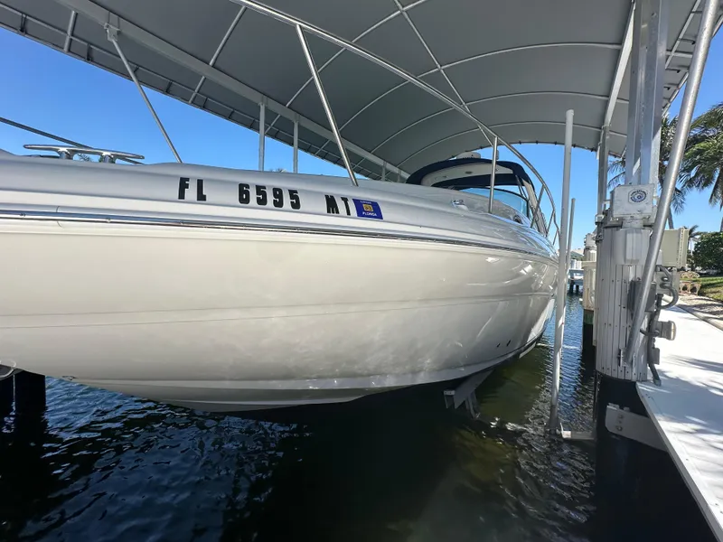 Slide: The Image of 2005 Sea Ray 320 Sundancer boat docked under canopy, side view. - 9