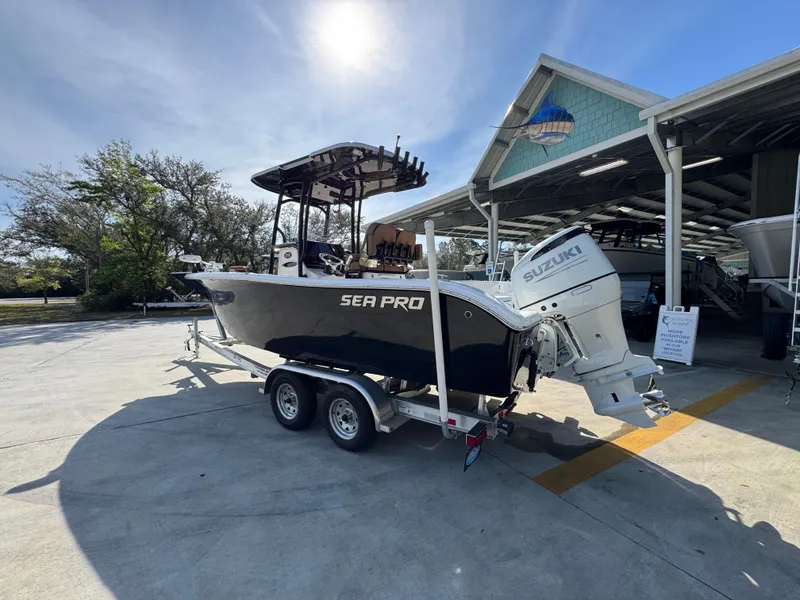 Slide: The Image of 2023 Sea Pro 219 Deep V CC boat on trailer, parked outdoors near a marina. - 18
