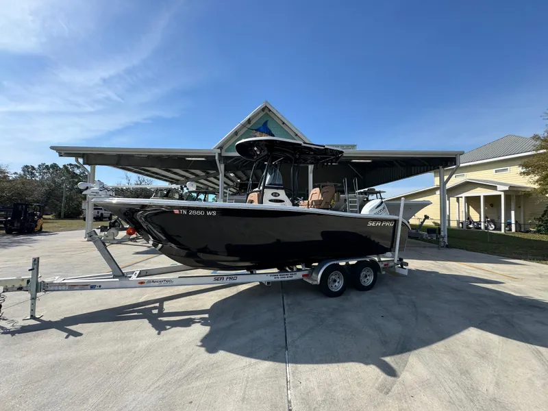 Slide: The Image of 2023 Sea Pro 219 Deep V CC boat on trailer, parked outdoors under clear sky. - 2