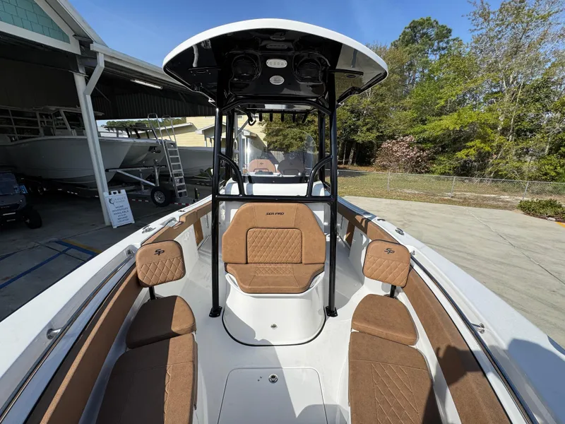 Slide: The Image of 2023 Sea Pro 219 Deep V CC boat with brown seating and T-top, docked outdoors. - 23