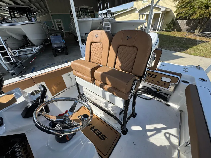 Slide: The Image of 2023 Sea Pro 219 Deep V CC boat interior with tan seating and steering wheel. - 28