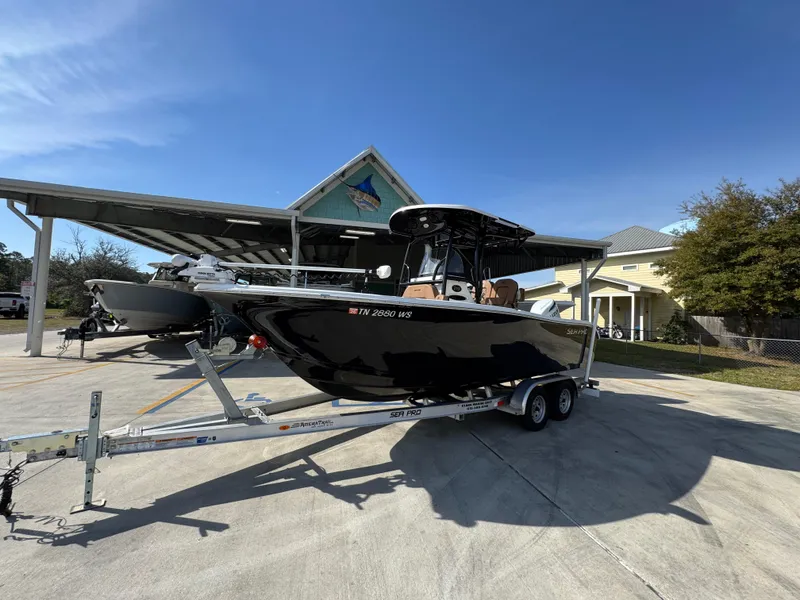 Slide: The Image of 2023 Sea Pro 219 Deep V CC boat on trailer, parked outdoors under clear blue sky. - 3