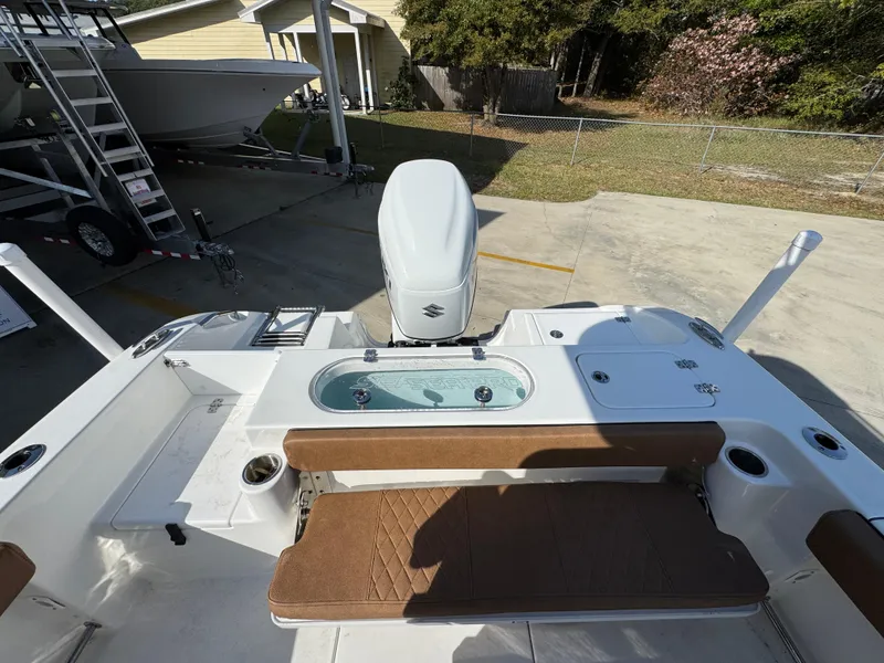 Slide: The Image of 2023 Sea Pro 219 Deep V CC boat with seating and outboard motor in a driveway. - 36