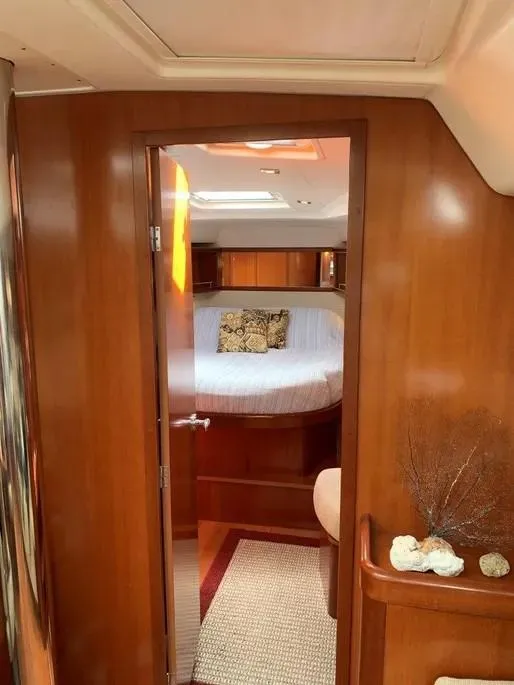 Slide: The Image of Interior of 2007 Beneteau 49' Cruiser, featuring a cozy cabin with wooden finishes. - 13