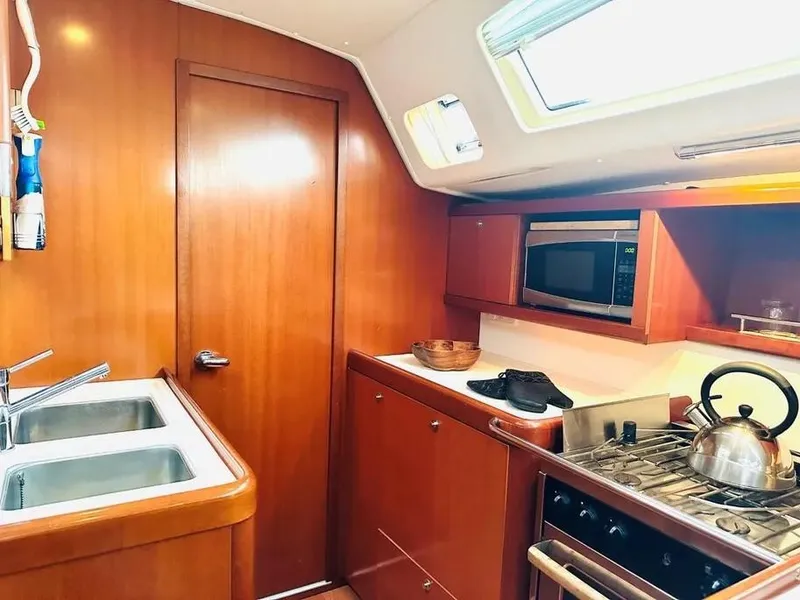 Slide: The Image of Galley kitchen in 2007 Beneteau 49' Cruiser with wood cabinetry and modern appliances. - 18