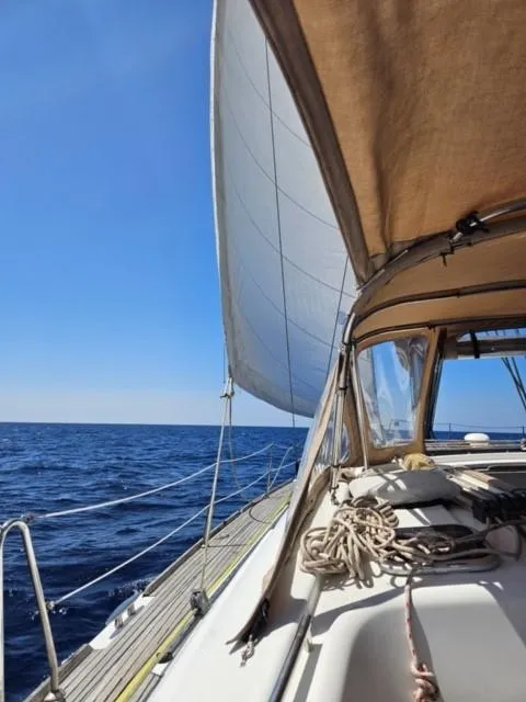 Slide: The Image of 2007 Beneteau 49' Cruiser sailing on open sea under clear blue sky. - 2