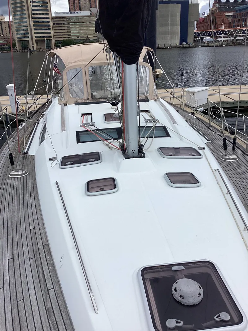 Slide: The Image of 2007 Beneteau 49' Cruiser sailboat docked, showcasing sleek deck design and urban waterfront backdrop. - 31