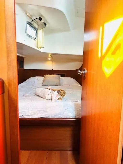 Slide: The Image of Cozy cabin interior of a 2007 Beneteau 49' Cruiser with a neatly made bed. - 8