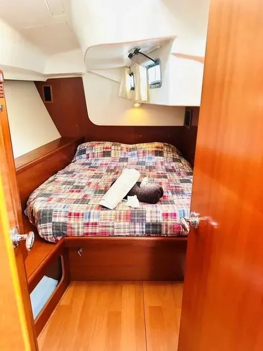 Slide: The Image of Cozy cabin interior of 2007 Beneteau 49' Cruiser with plaid bedding and wooden finishes. - 9