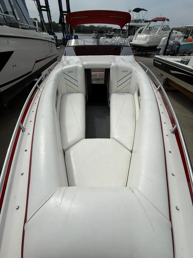 Slide: The Image of 2003 Lavey Craft 2750 NUERA boat with white seating and red accents, docked among other boats. - 11