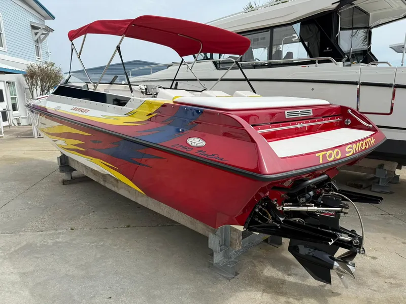 Slide: The Image of 2003 Lavey Craft 2750 NUERA boat with vibrant red and yellow design, docked outdoors. - 4