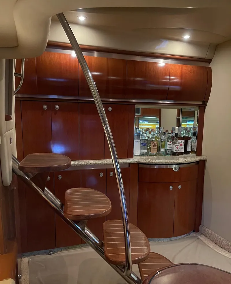 Slide: The Image of Luxurious interior of 2005 Sea Ray 500 Sundancer yacht with elegant wooden cabinetry and bar area. - 10