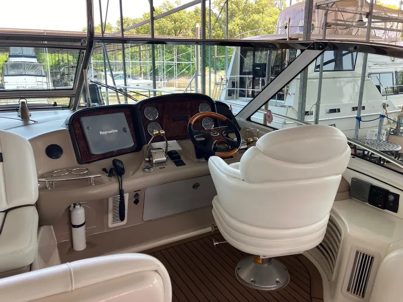 Slide: The Image of 2005 Sea Ray 500 Sundancer helm with white seating and navigation equipment. - 5