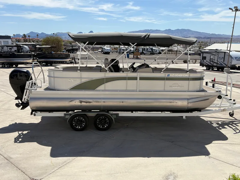 Slide: The Image of 2019 Bennington 23 SXP pontoon boat on trailer, parked outdoors under clear sky. - 2