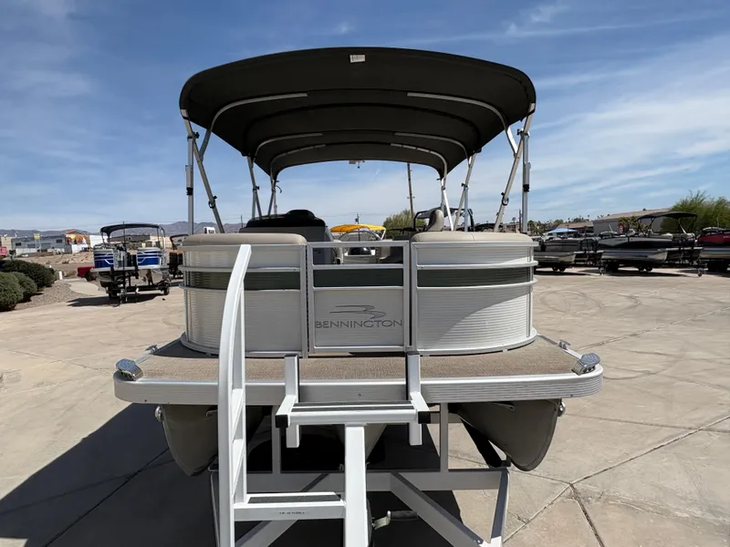Slide: The Image of 2019 Bennington 23 SXP pontoon boat with canopy, displayed outdoors on a sunny day. - 3