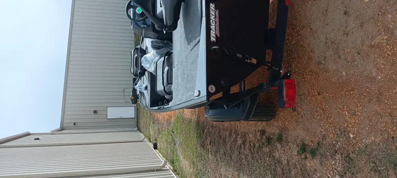 Slide: The Image of 2025 Tracker Bass Tracker Classic XL boat parked on gravel near a building. - 17