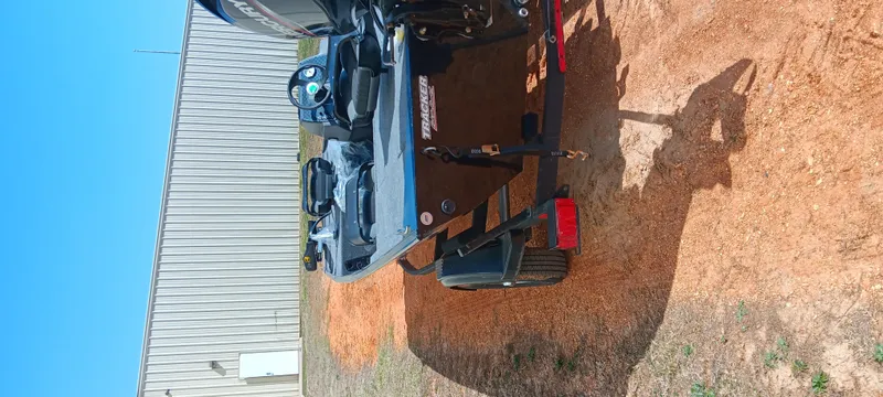 Slide: The Image of 2025 Tracker Bass Tracker Classic XL boat on a trailer, parked on dirt. - 2