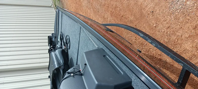 Slide: The Image of 2025 Tracker Bass Tracker Classic XL boat on a trailer, parked on gravel. - 23