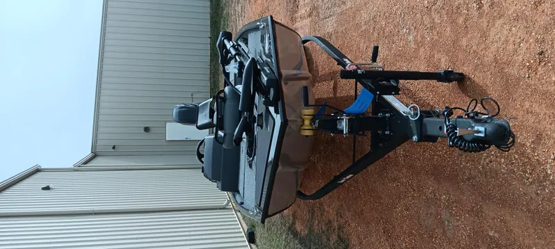 Slide: The Image of 2025 Tracker Bass Tracker Classic XL boat on trailer, parked on gravel near a building. - 25