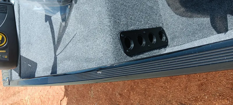 Slide: The Image of 2025 Tracker Bass Tracker Classic XL boat interior with rod holder on carpeted deck. - 4