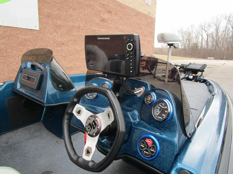 Slide: The Image of 2013 Bass Cat Sabre boat dashboard with steering wheel and navigation system. - 4
