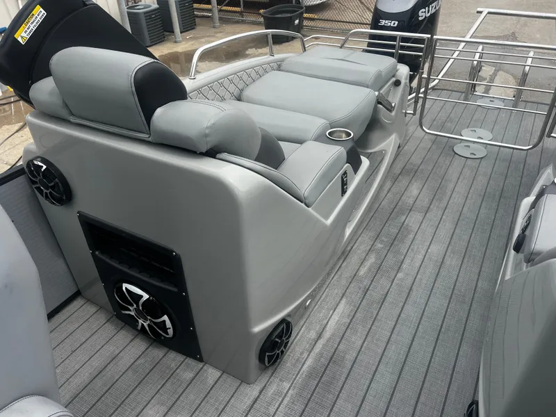 Slide: The Image of 2022 Manitou 27 boat interior with gray seating and speakers. - 5