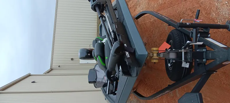 Slide: The Image of 2025 Ranger RT188C boat on trailer, parked on red dirt near a building. - 2