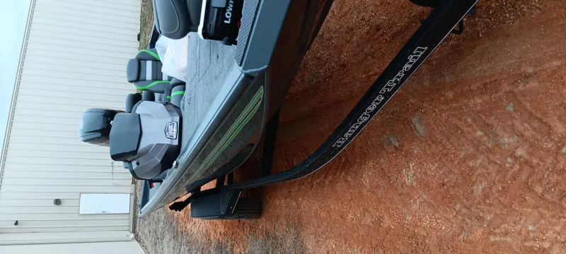 Slide: The Image of 2025 Ranger RT188C boat on trailer, parked on dirt near a building. - 3