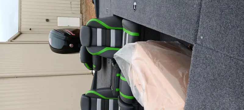 Slide: The Image of 2025 Ranger RT188C boat interior with black and green seats, covered console, and outboard motor. - 6