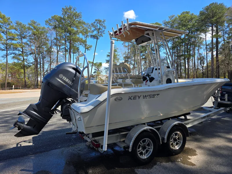 Slide: The Image of 2019 Key West 203 FS boat on trailer with Yamaha outboard motor, parked outdoors. - 1