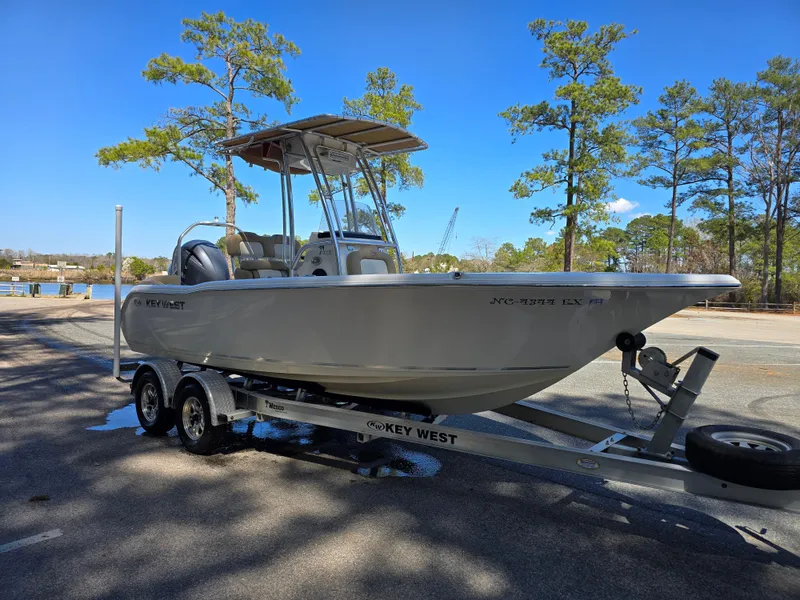 Slide: The Image of 2019 Key West 203 FS boat on trailer in sunny parking lot. - 2