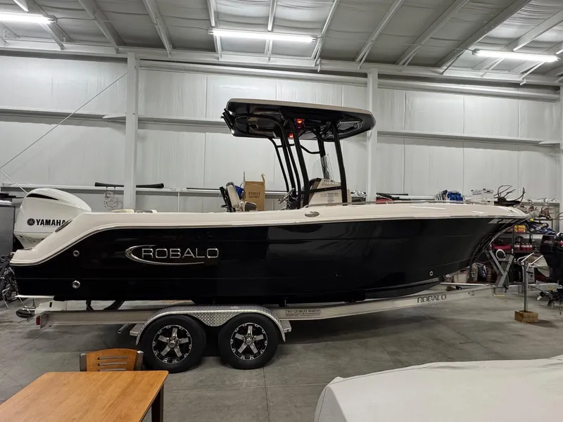 Slide: The Image of 2019 Robalo R242 Explorer boat on trailer in indoor storage facility. - 0