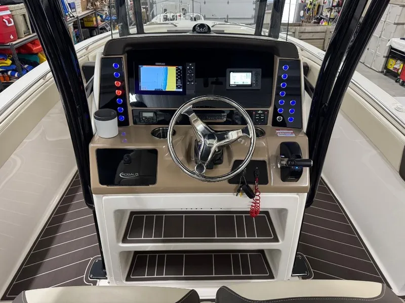Slide: The Image of 2019 Robalo R242 Explorer boat dashboard with steering wheel and navigation displays. - 13